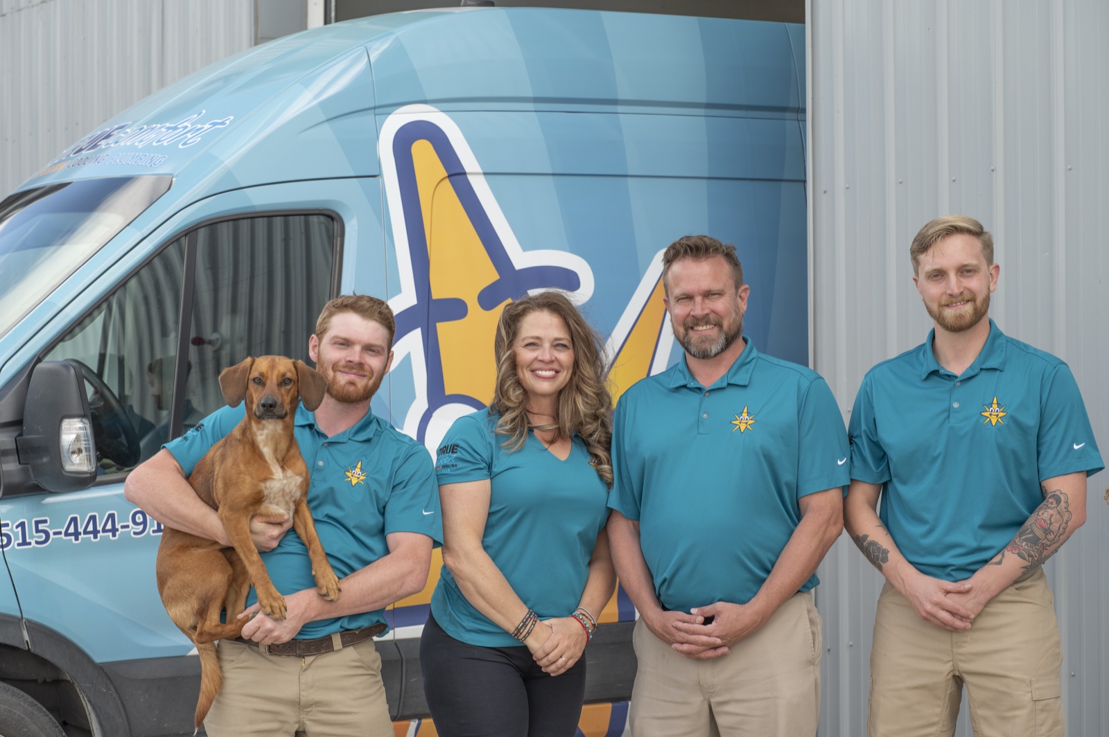 The True Comfort family and their dog in front of a branded service van