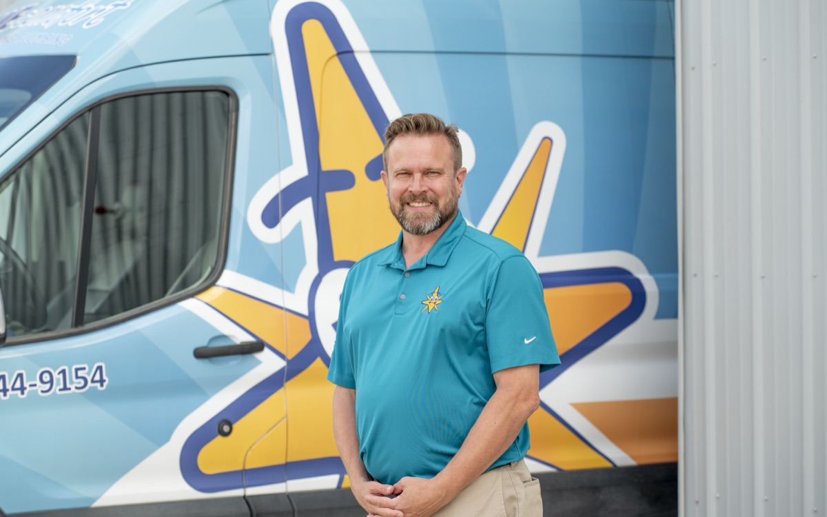 The founder of True Comfort in front of a company service van