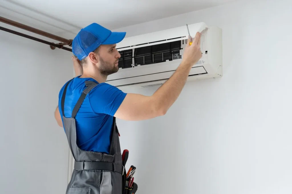 AC Installation in West Des Moines, IA 1 Maletechnicianinoverallsandabluecaprepairsanairconditioneronthewallstockphoto 1920w
