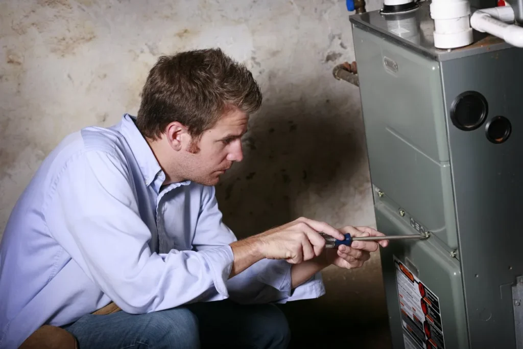 Furnace Replacement in Urbandale, IA 1 ServiceManWorkingonFurnacestockphoto 1920w
