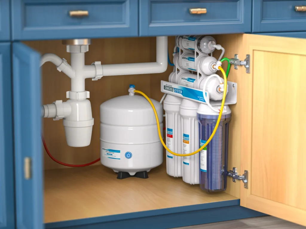 Under-sink reverse osmosis water filtration system installed in blue kitchen cabinet in Des Moines, IA.